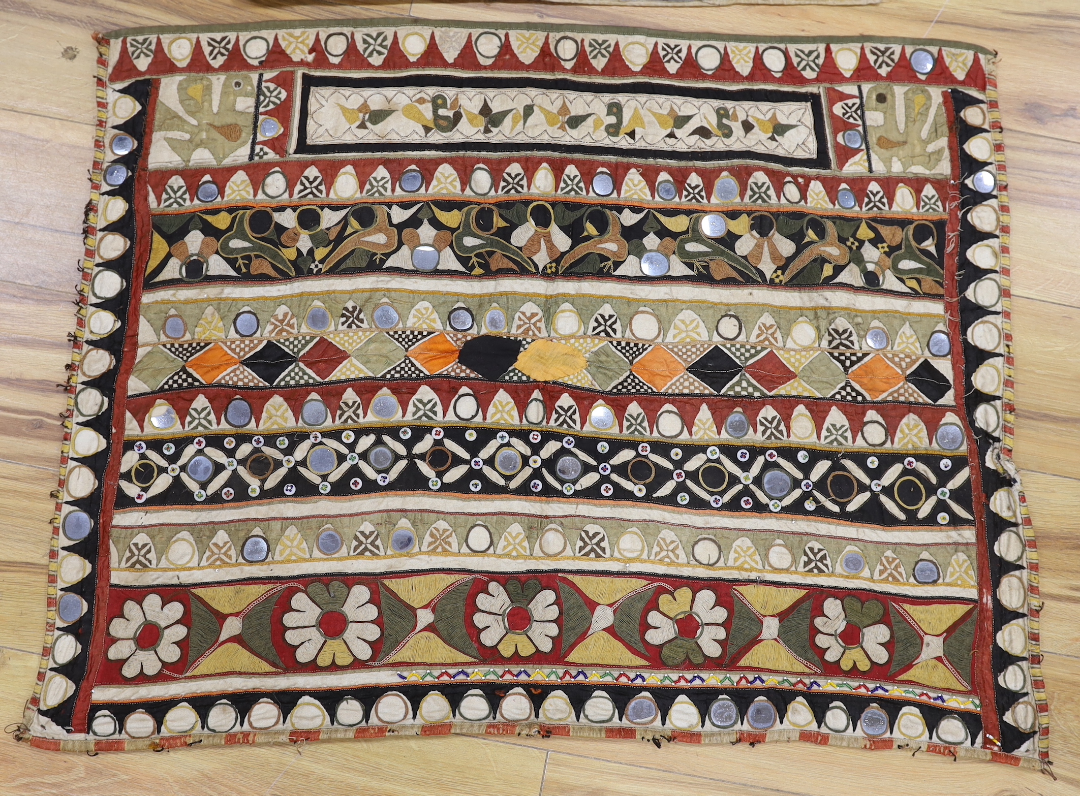 Two Indian embroidered and mirrored panels, possibly wall hangings, the largest 86cm x 67cm